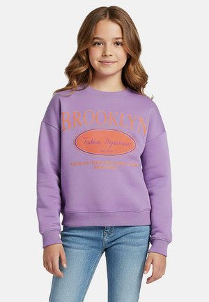 Paarse sweatshirt met oranje "BROOKLYN" graphic, ronde hals, verlaagde schouders en geribde manchetten, gecombineerd met lichtblauwe spijkerbroek.
