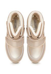 Beige párnázott sportcipők sima, fényes felülettel és puha szőrme béléssel. Jellemzője a tépőzáras pánt és a kontrasztos fehér varrás.