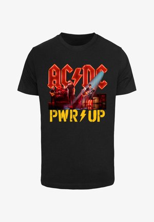 Fekete pamut póló, piros "AC/DC" logóval, villámformával és élénk sárga "PWR UP" felirattal, a póló közepén egy zenekari grafikával.