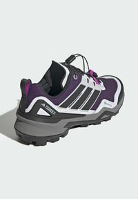 Lila und schwarze Trail-Schuh mit einem strukturierten Mesh-Obermaterial, weißen Streifen und einer stabilen grauen Gummisohle. Verfügt über ein schnelles Schnürsystem und Gore-Tex-Branding.