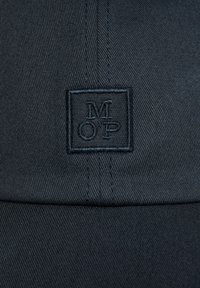Black cap with a textured, woven fabric. Features a square patch with "MOP" embroidered in dark thread on the front.