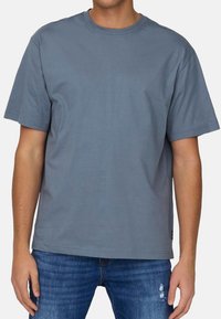 Graues Baumwoll-T-Shirt mit kurzen Ärmeln und Rundhalsausschnitt. Schlichtes Design, lockere Passform und keine sichtbaren Muster oder Akzente.