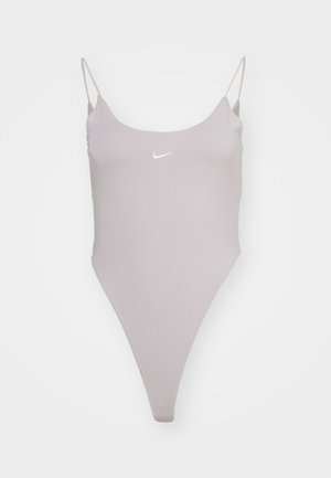 Svetlošedý jednodielny plavky s tenkými ramienkami, okrúhlym výstrihom, vysokým strihom nohavíc a malým bielym logom Nike na prednej strane. Hladká textúra látky.