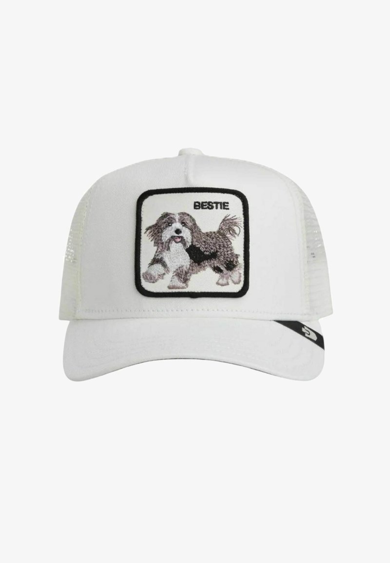 Casquette trucker blanche en mesh avec un patch représentant un chien noir et blanc duveteux brodé et le mot « BESTIE » au-dessus.