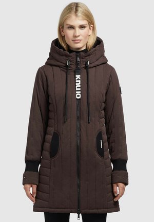 Brown quilted long jacket with a hood, zip front, black accents on pockets and cuffs, and a logo on the zipper pull.