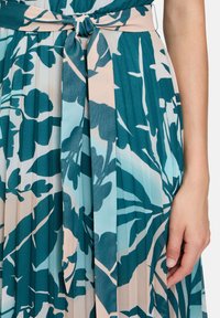 Sukienka w kwiatowy wzór w odcieniach teal i różu; plisowany materiał z paskiem wiązanym w talii; gładka faktura z półprzezroczystymi elementami.