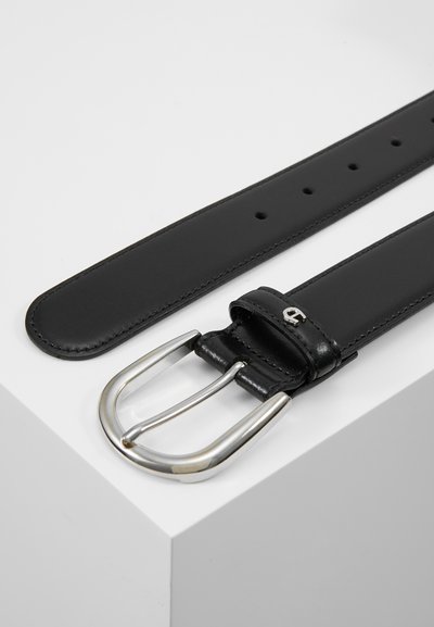 Cinturón de cuero negro con una hebilla rectangular plateada brillante. Presenta seis agujeros para ajustar y una textura suave. Detalle de costura en el borde visible.