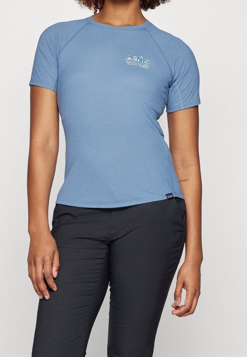 Světlomodrá košile s krátkým rukávem, kulatým výstřihem a raglánovými rukávy. Na horní části hrudi je barevné logo. Měkká, hladká tkanina.