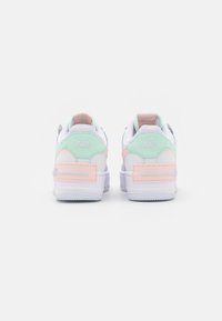 Nike tenisice s bijelom kožnom podlogom, mint zelenim, pastelnim rosalim i lavandom naglascima, teksturiranim đonom i izvezenim logotipima.