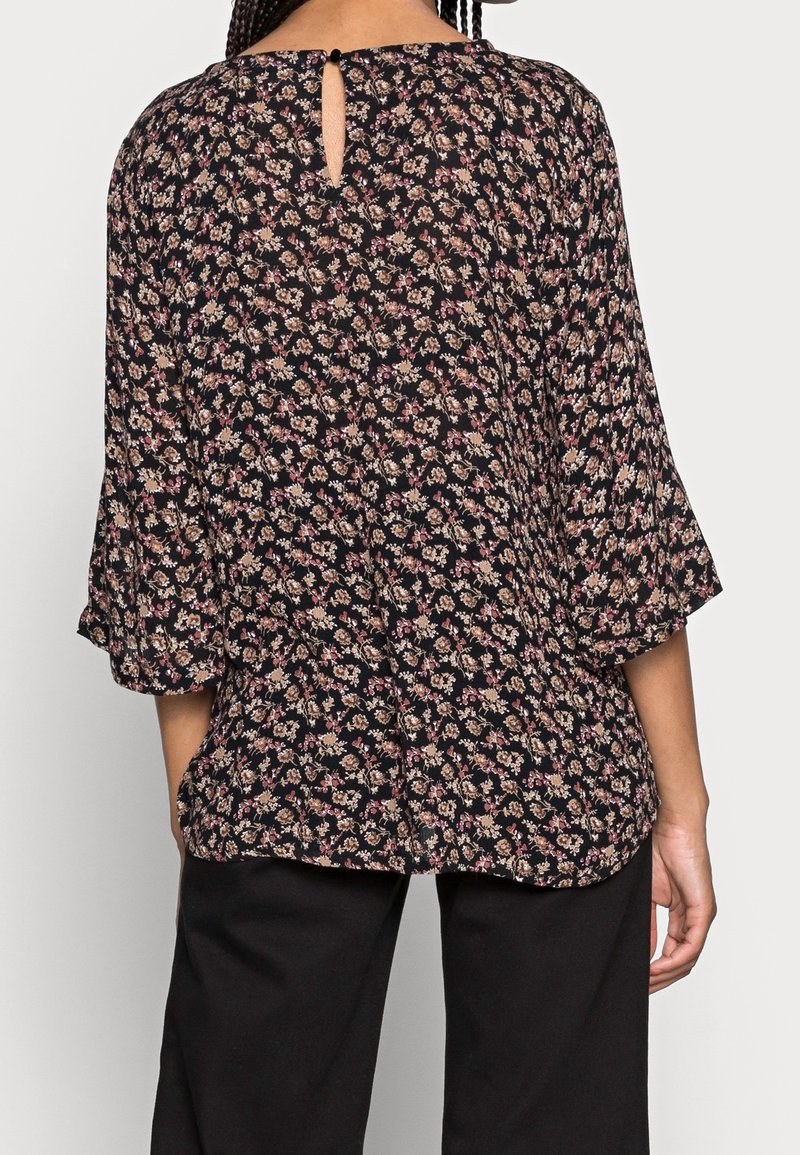 Blouse fleurie à manches trois-quarts, base noire avec petites fleurs multicolores, détail dos en trou de serrure, tissu léger, coupe décontractée.