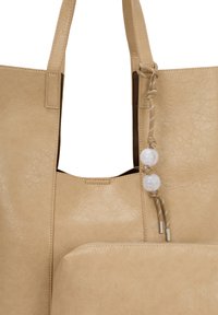 Beige læder tote taske med struktureret overflade, to håndtag og en dekorativ snor med hvide perler. Inkluderer en matchende lynlås-pose.