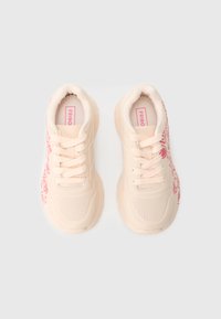 Joggesko laget av lyst rosa syntetisk materiale med teksturerte detaljer, med et blomstertrykkdesign og lisser for sikker lukking.
