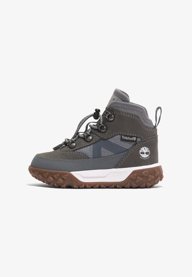 Botte de randonnée imperméable Timberland grise et marron avec fermeture à lacet, col rembourré et semelle robuste texturée.