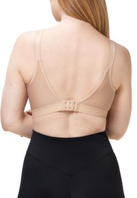 Kapea beige liivi säädettävillä olkahihnoilla ja takana hakaskiinnitys. Sujuva pinta, yhdistettynä korkeavyötäröisiin mustiin legginsseihin.
