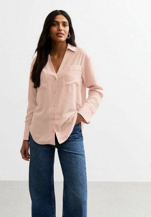Lichtroze blouse met lange mouwen, kraag, notch-neklijn, enkele borstzak en knopen aan de voorkant, gecombineerd met donkerblauwe wijde jeans.