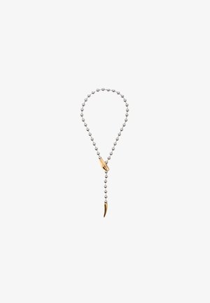 Srebrny naszyjnik z koralikami z złotym akcentem i zawieszką w kształcie pazura. Design jest wydłużony z wiszącym detalem.