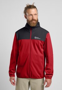 Rood en zwarte zipjack met capuchon, gemaakt van gladde stof. Logo op de borst, lange mouwen met elastische manchet, lichtgewicht ontwerp.