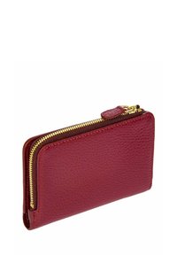 Portefeuille en cuir rouge avec une finition texturée. Présente une fermeture éclair dorée le long du bord et un petit onglet en cuir. Forme rectangulaire compacte.