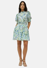 Vestido corto de manga corta con estampado floral, en tonos de azul y verde. Presenta una cintura ajustada y dos bolsillos laterales.