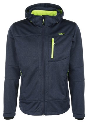 Man loopt en draagt een marineblauwe jas met neongele voering, een grijs hemd, zwarte cargobroek en zwarte wandelschoenen.