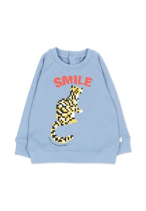 Maglietta a maniche lunghe per bambini azzurro chiaro con grafica pixelata di tigre gialla e nera e la parola "SMILE" in lettere maiuscole rosse sopra.