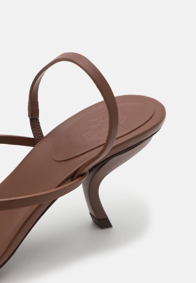 Sandal de tacón alto marrón que presenta un diseño de tiras estrechas, textura de cuero suave y un elegante tacón de aguja.