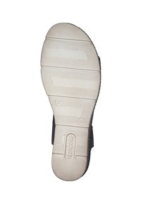 Black sandal sole with prominent white rubber tread, featuring grooves for traction. Markings include size 37 and brand logo.