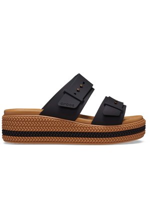 Sort slip-on sandal med to justerbare remme, tan flettet platformsål med en sort fletstribe og polstret fodseng.