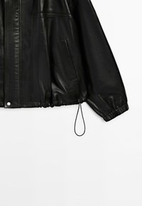Black faux leather jacket with front pocket, front seam detail, elastic cuffs, and an adjustable drawstring hem, shown against a white background.