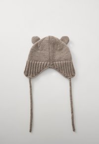 Cappello trapper lavorato a maglia beige con orecchiette, orecchie di orso sulla parte superiore e lacci. La texture morbida e il dettaglio a coste sul bordo aumentano calore e vestibilità.