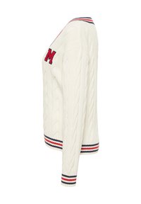 Kremowy kardigan z splotem w warkocze, z czerwonym haftowanym "M" oraz ribbowymi akcentami w niebiesko-czerwone paski na dekolcie i mankietach.