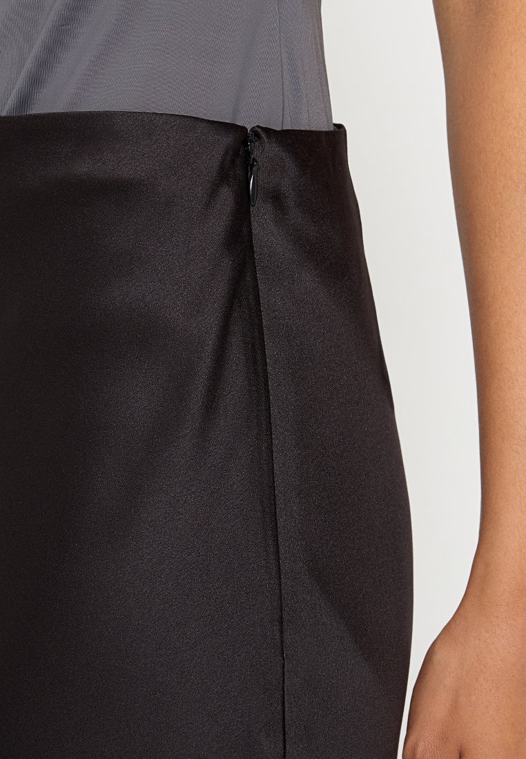 Schwarzer Bleistiftrock mit einer glatten, eleganten Textur. Verfügt über einen unauffälligen seitlichen Reißverschluss und eine figurbetonte Silhouette. Teil eines geschichteten Outfits.