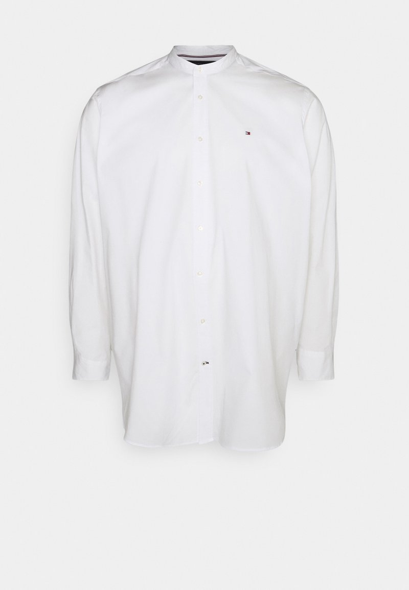 Chemise blanche à manches longues avec boutons, col mao et petit logo rouge, blanc et bleu sur la poitrine gauche.