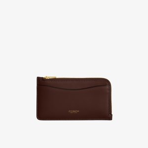 Λεπτή καφέ δερμάτινη θήκη για κάρτες με χρυστό φερμουάρ και μπροστινή τσέπη, λογότυπο Coach New York ανάγλυφο σε χρυσό.