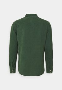 Camicia verde in velluto a coste a maniche lunghe, presenta un colletto classico, polsini con bottoni e una sottile trama a coste verticali sul tessuto.