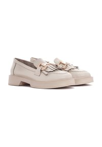 Mocassins en cuir beige clair avec une tige texturée, des accents de gland décoratifs et du matériel doré, dotés d'une semelle épaisse et compensée.