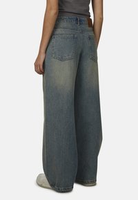 Wijdere denim jeans in lichtblauw, met een hoge taille, twee achterzakken en een licht vervaagde textuur. Versterkte stiksels bij de zoom.