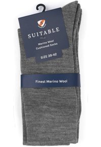 Gevoerde merinowollen sokken in donkergrijs met een zachte textuur. Verpakt met een merklabel met maat 39-42 en productdetails.