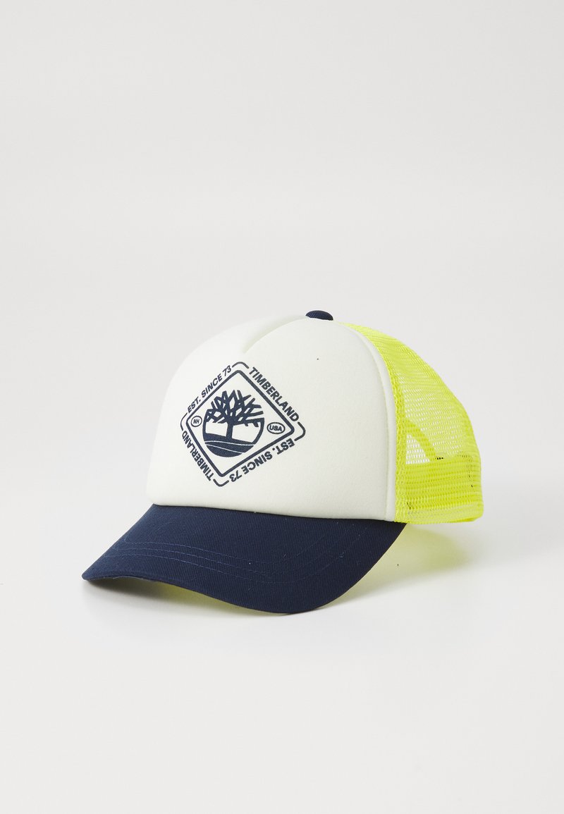 Fehér és sötétkék baseball sapka, sárga hálós oldalakkal, fán logo-val és a 'Timberland' felirattal. Puha anyagból készült, ívelt csúccsal.