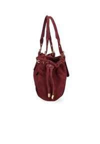 Sac seau en suède bordeaux avec œillets en métal doré et extrémités à bascule, doté de double bandoulières et d'une fermeture à cordon.
