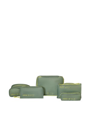 Five green travel packing cubes with yellow trim, each labeled with icons representing types of clothing or items for organized packing.