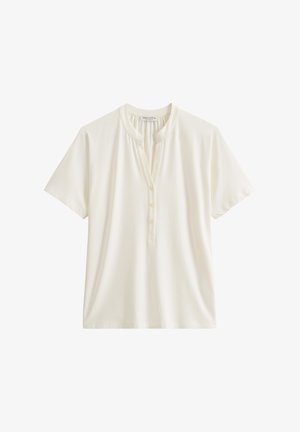 Short-sleeve, cream T-shirt made of soft fabric, featuring a round neckline, button placket, and a relaxed fit. Smooth texture throughout.