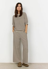 Ribade loungewear komplekt, mis sisaldab vabalt istuvat lühikeste varrukatega toppi ja laiad püksid, pruun ja kreem värvitoonis, küljetaskutega.