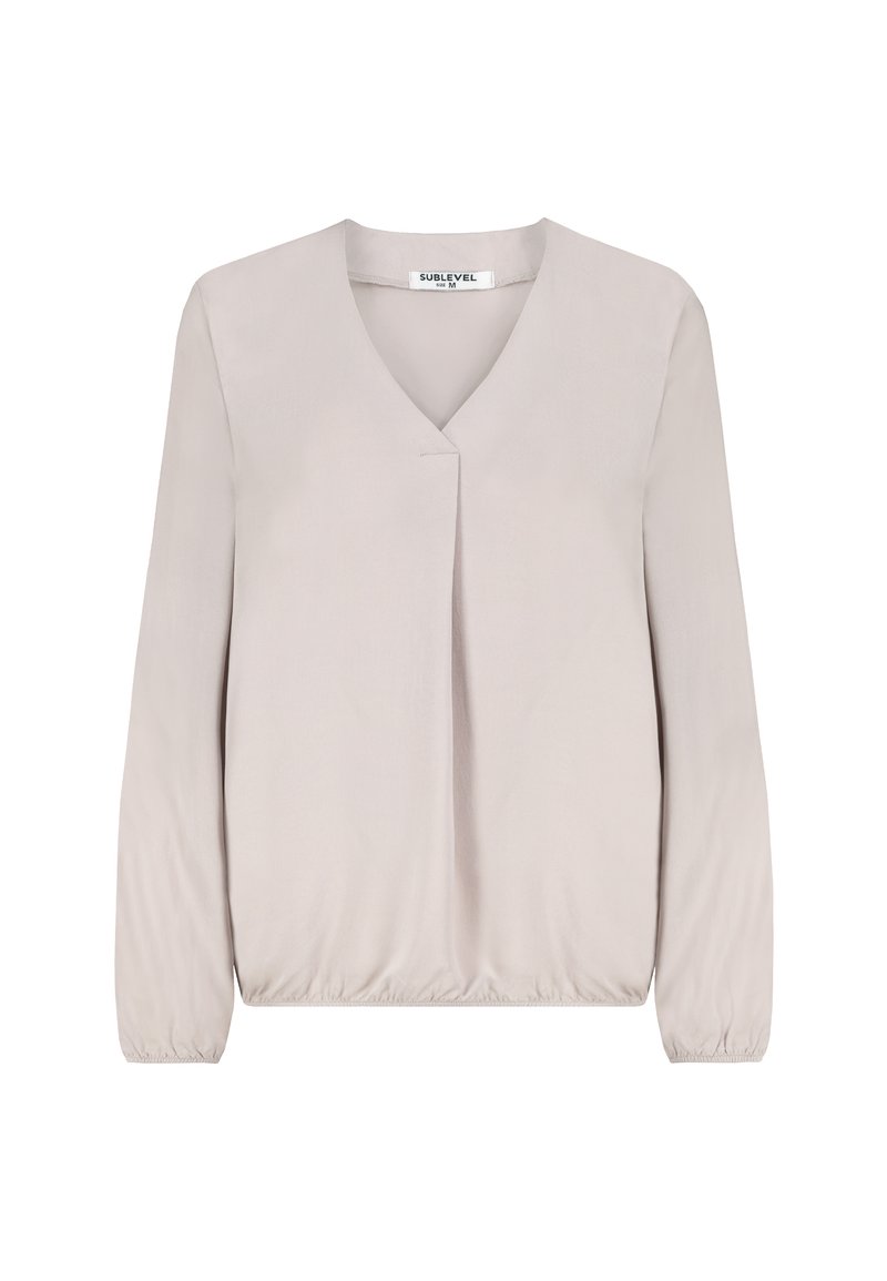 Light beige long-sleeve blouse with V-neck, subtle front pleat, elastic cuffs, and elastic hem, size medium, displayed on white background.