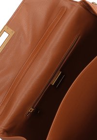 Interno della borsa a mano in pelle marrone con texture liscia, dotato di una tasca con cerniera e due scomparti aperti. Visibili dettagli in hardware dorato.