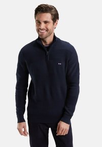 Sweat à zip bleu marine avec des rayures horizontales texturées. Dispose d'un col montant et d'un petit logo sur la poitrine. Motif en tricot lisse.