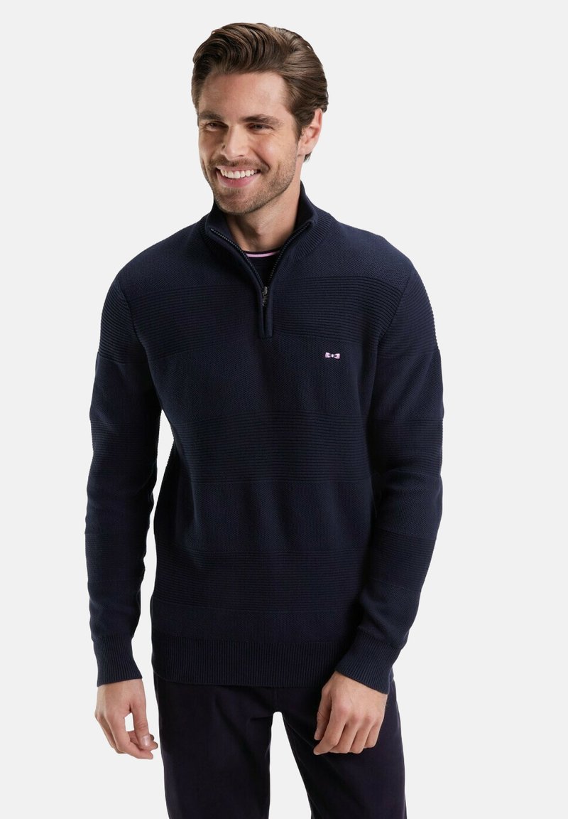 Sweat à zip bleu marine avec des rayures horizontales texturées. Dispose d'un col montant et d'un petit logo sur la poitrine. Motif en tricot lisse.