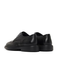 Zwarte leren dresschoenen met een gladde afwerking, wingtip ontwerp, geperforeerde accenten, ronde neus en een platte rubberen zool.