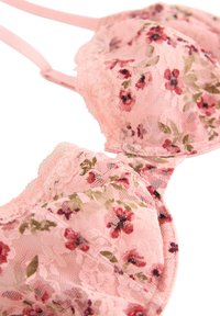 Sutien din dantelă roz, cu un model floral, având accente mici roșii și verzi. Designul include o margine delicată și curele ajustabile.