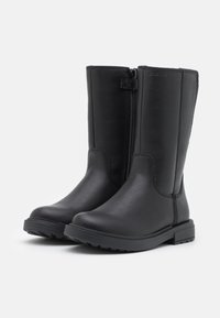 Bottes noires en cuir montant jusqu'au genou avec une fermeture éclair latérale, présentant une texture lisse, un bout arrondi et une semelle en caoutchouc durable pour l'adhérence.